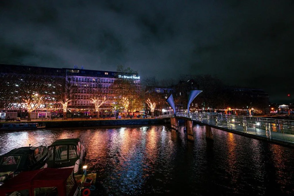 a city at night with lights on the water at The Bristol Hotel in Bristol
