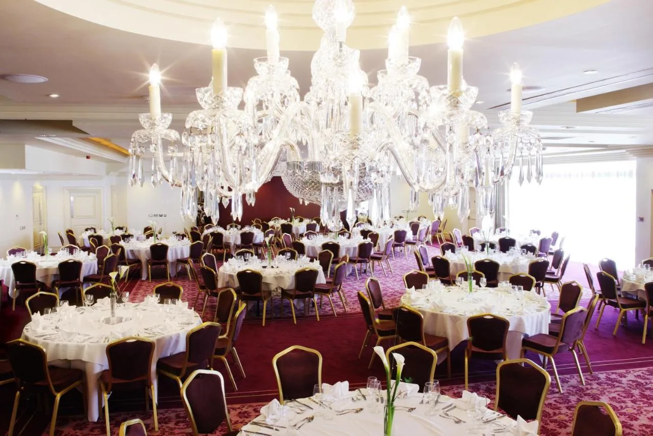 a room filled with tables and chandeliers at The Bristol Hotel in Bristol